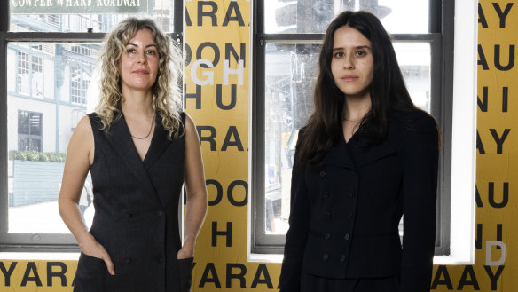 Co-authors of the Countess Report, Miranda Samuels and Shevaun Wright in front of Gamilaraay/Wailwan/Biripi artist r e a’s GARI (language), 2024, for the 24th Biennale of Sydney, Ten Thousand Suns, 2024, Artspace. GARI (language) was commissioned by Biennale of Sydney and Artspace. Courtesy of the artist. © r e a. 



