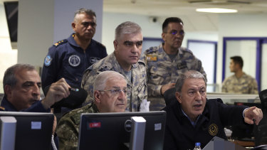 Turkey’s Defence Minister Hulusi Akar, right, and top army commanders work at the Air Force command centre, in Ankara as Turkey launches strikes into Syria.