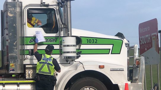 Police check a truck driver's permit on the Victoria-South Australia border last month. 