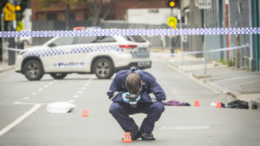 An officer photographs evidence left at the scene of the fatal Love Machine nightclub shooting in Prahran in 2019.