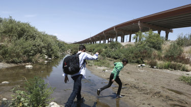 People cross the Rio Grande from Chihuahua, Mexico, into the US to turn themselves over to authorities and ask for asylum.