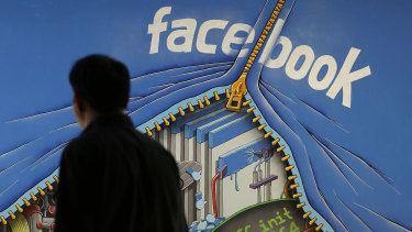 A man walks past a mural in an office on the Facebook campus in Menlo Park, California.