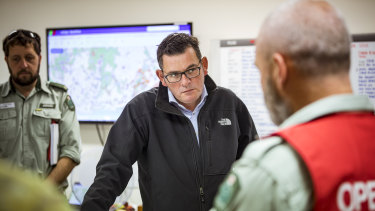 Premier Daniel Andrews is briefed by emergency services personnel. 