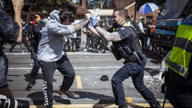 A police officer uses capsicum spray on a protester during Melbourneâs anti-lockdown rally. 