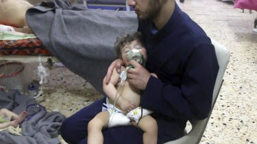 A medical worker gives a toddler oxygen following an alleged poison gas attack in Douma on Saturday.