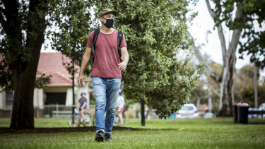 Chris Parisi wears a mandatory facemask while walking in Brunswick Park. 