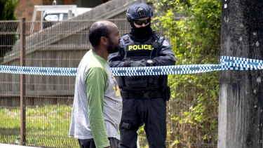 A family friend talks to police outside a house being raided in Werribee in connection to Hassan Khalif Shire Ali.