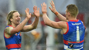 Cody Weightman of the Bulldogs is congratulated by Adam Treloar at a wet Launceston.