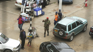 A soldier controls a fuel queue in Harare on Tuesday. 