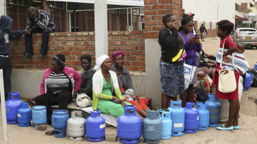 People wait in a queue for cooking gas at a garage in Harare on Wednesday.