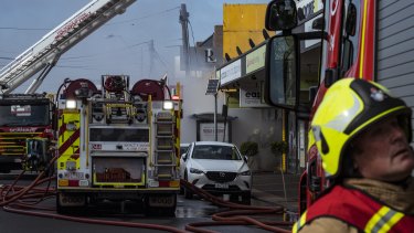 Fire crews outside the Clark Rubber shop front in Niddrie on Saturday. 