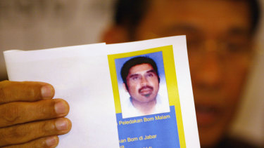 An Indonesian Police Officer shows an undated photo of suspected al-Qaeda operative Hambali during a news conference in 2003.