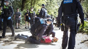 Police arrest a man during Saturday’s protests. 