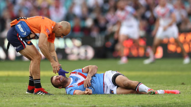 James Tedesco receives assistance after being floored by Jordan Pereira.
