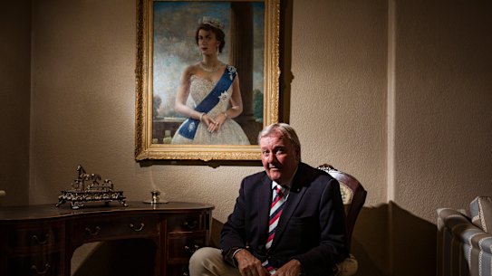 Constitutional monarchist Jason Ronald at home with a portrait of the Queen.