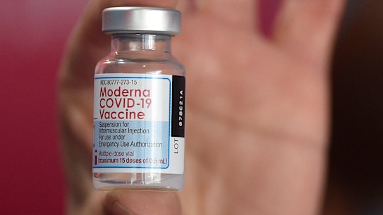 A health worker shows a vial of the Moderna vaccine for COVID-19.