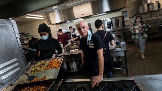 Alex Dekker and other volunteers prepare meals in the large council catering kitchen his burgeoning organisation has had to rent to cater for demand.