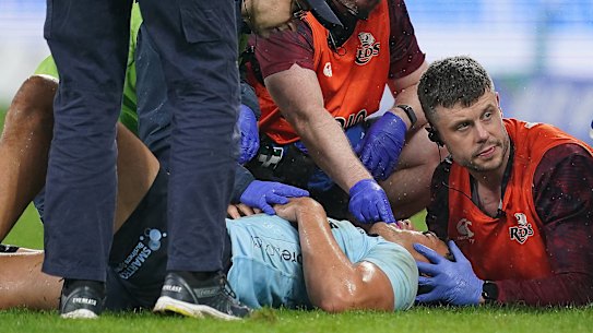 Joseph-Aukuso Suaalii is treated after a bad head knock on Friday night by Waratahs and Reds medical teams