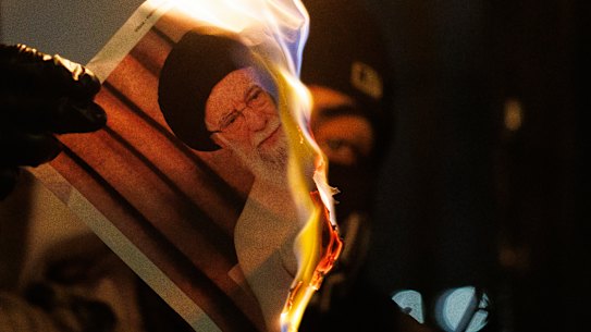 Um manifestante queima uma imagem de Ali Khamenei durante um protesto em frente à Embaixada do Irã em 14 de janeiro.