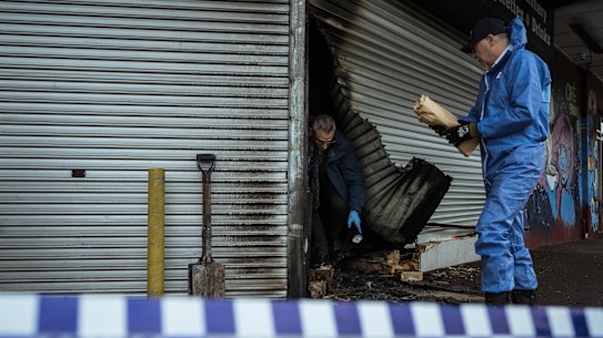Police and arson investigators on the scene at another tobacco store arson attack in Hadfield last August.