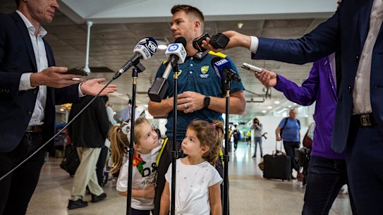 David Warner gets some help from his daughters as he speaks to the press at Melbourne Airport.