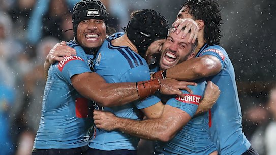 Blues Fullback James Tedesco is mobbed by team-mates after scoring the winning try in the dying moments of the State of Origin opener at Accor Stadium on Wednesday night.