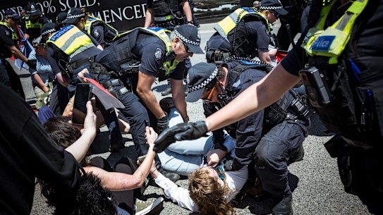 Police arrest a protester outside Flemington on Tuesday.