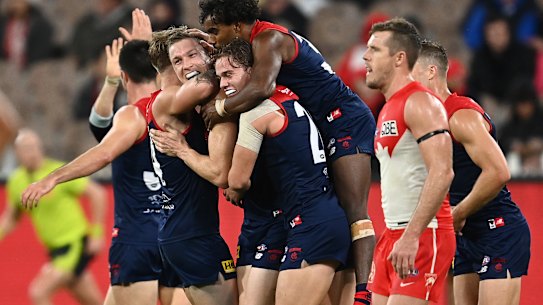 Melbourne has won its first eight games for the first time since 1965 after holding off the Swans.