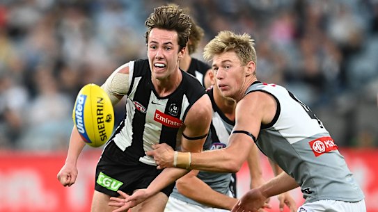 MELBOURNE, AUSTRALIA - MAY 23: Tyler Brown of the Magpies handballs whilst being tackled by Todd Marshall of the Power during the round 10 AFL match between the Collingwood Magpies and the Port Adelaide Power at Melbourne Cricket Ground on May 23, 2021 in Melbourne, Australia. (Photo by Quinn Rooney/Getty Images)