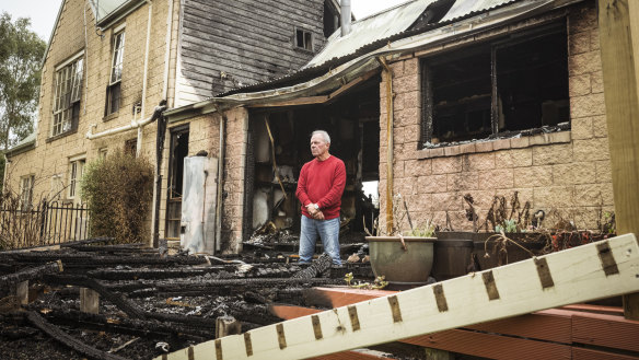 Sunbury home owner Jim Johnstone amid the burnt out remains of the home he shared with wife Maria.  Jim and Maria’s Sunbury house burned down after a lithium pool cleaner battery combusted whilst sitting on their outdoor decking.