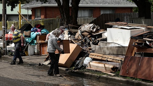 People clean out flood-damaged belongings in Maribyrnong on Sunday. 