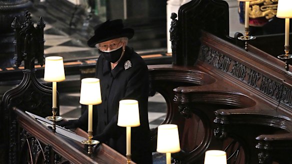 The Queen stands as Prince Philip’s coffin is carried into St George’s Chapel.