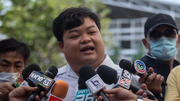 Activist Parit "Penguin" Chiwarak talks to reporters before one of his court appearances in Bangkok.