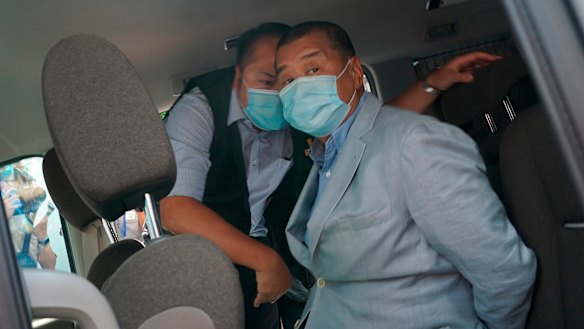 Jimmy Lai, who founded local newspaper Apple Daily, is arrested by police officers at his home in Hong Kong on Monday.