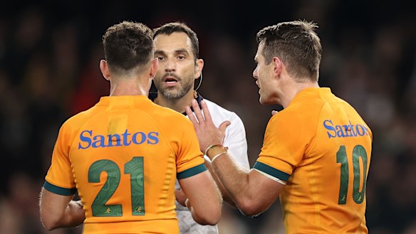 Referee Mathieu Raynal speaks to Nic White and Bernard Foley.