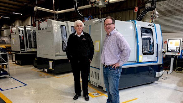 Pat Boland, co-founder and director of ANCA and Mark Patman at ANCA's factory in Bayswater with the machines manufacturing components for the ventilators. 