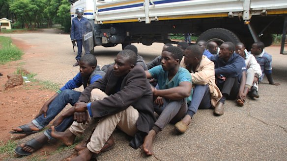 A policeman stands guard as protesters are arrested in Harare on Wednesday. 