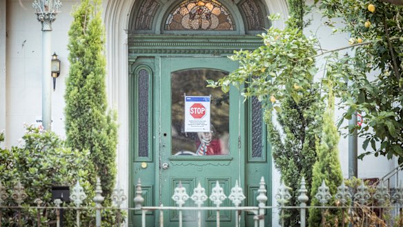 One resident peers from inside the locked down home on Monday morning.