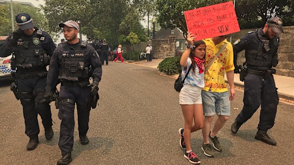 Izzy Raj-Seppings, 13, is led away from the protest  in December 2019 at Kirribilli House after police issue a move on order. 