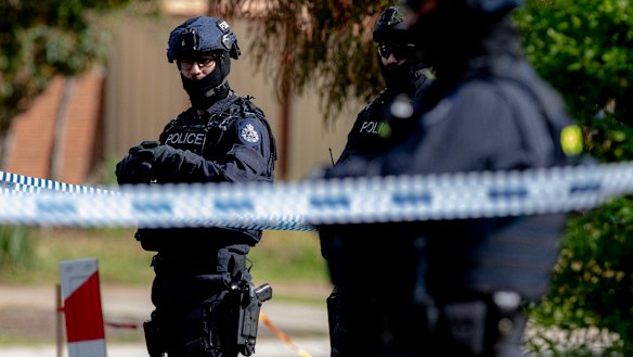 Police stand guard during a house raid in Werribee on Saturday following the Bourke Street attack.