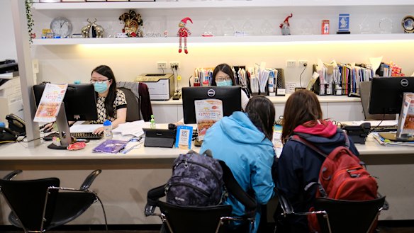 Travel agents wear masks at a store in Melbourne earlier this year.