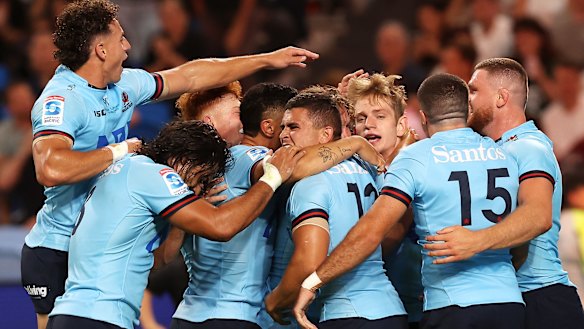 Waratahs players swamp Max Jorgensen after he scores against the Brumbies.
