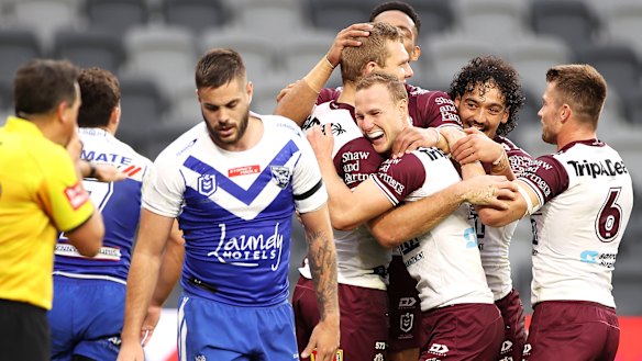 Tom Trbojevic celebrates one of his three tries with Sea Eagles teammates as Manly belted the Bulldogs 66-0.