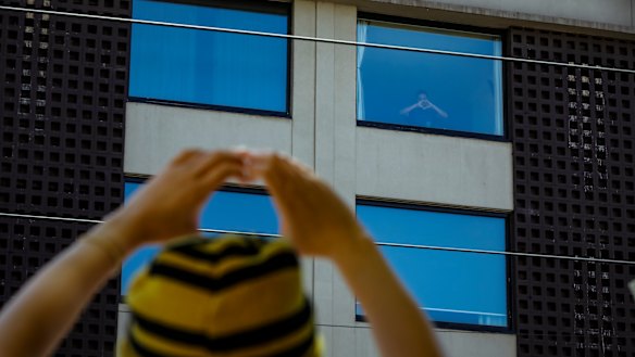 A Bangladeshi refugee signals 'joy' to protestors outside a Carlton hotel.