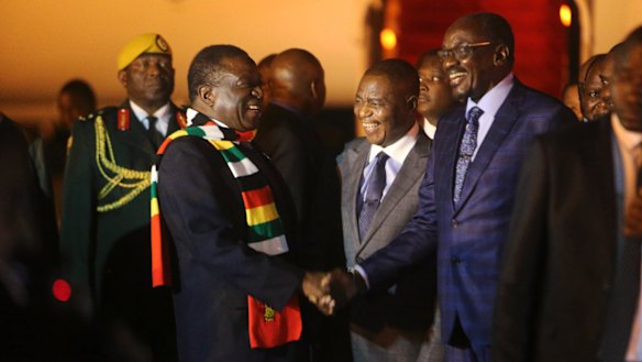 Zimbabwean President Emmerson Mnangagwa, left, is greeted as he arrives at Robert Mugabe International Airport in Harare on Monday.