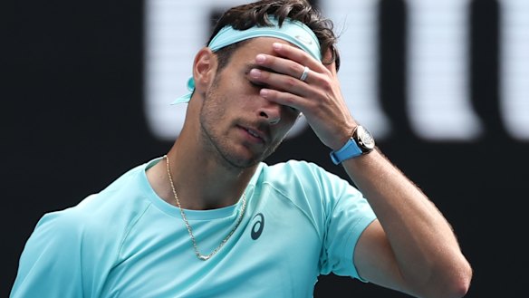Lorenzo Musetti reacts after retiring from his quarter-final against Novak Djokovic.