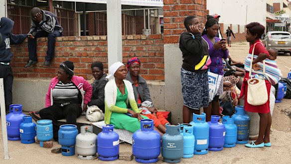 People wait in a queue for cooking gas at a garage in Harare on Wednesday.