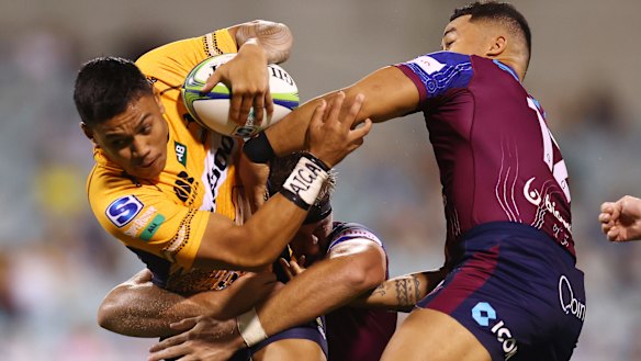 Len Ikitau takes the ball up against the Reds.