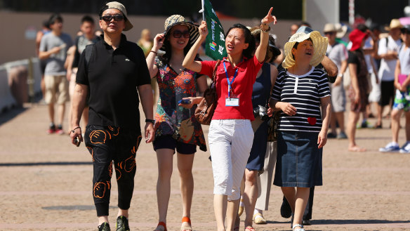 A guide points out the sights of Sydney to a group of Chinese tourists.