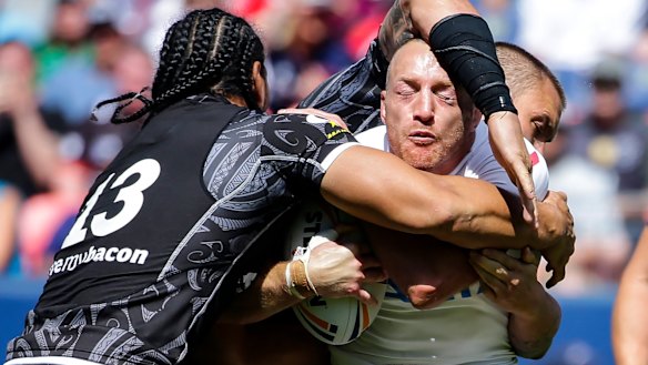Running blind: England's James Roby is wrapped up by Martin Taupau, left.